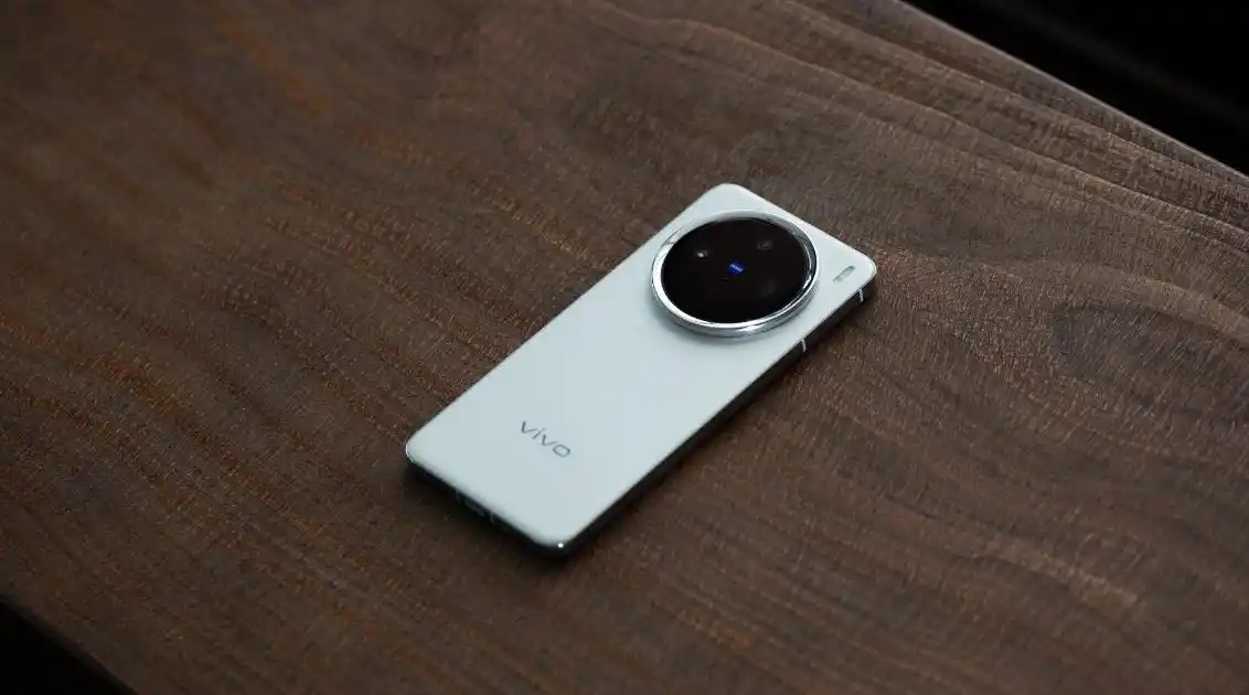 Vivo X300 smartphone with Zeiss-branded circular camera module placed on a wooden surface, showcasing its sleek silver design