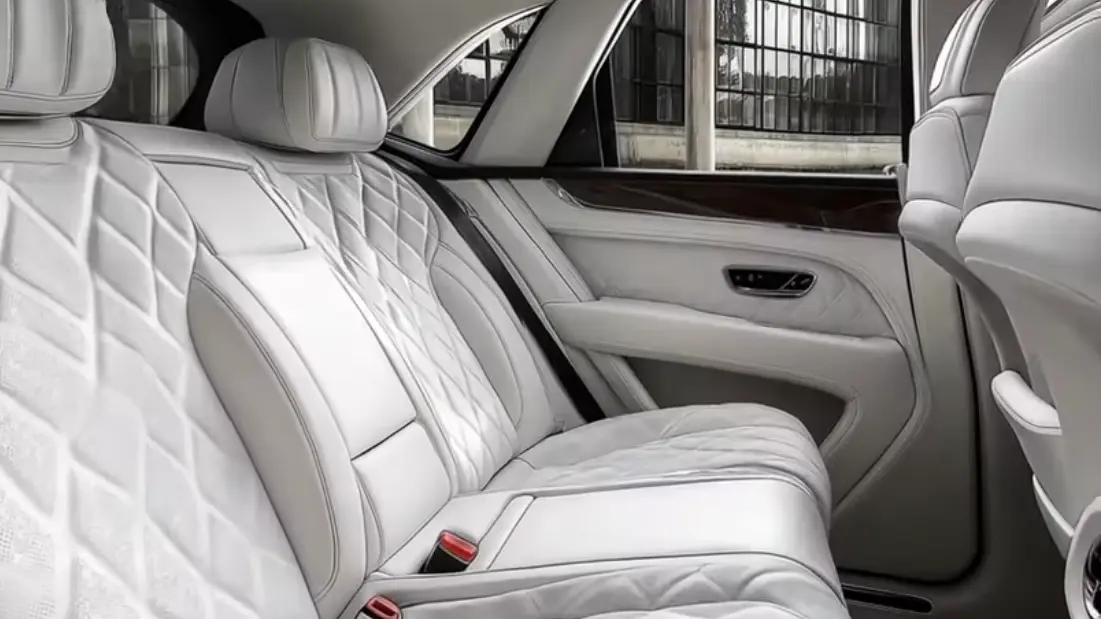 Rear seat interior of a luxury sedan featuring quilted leather upholstery, spacious legroom, and premium comfort features