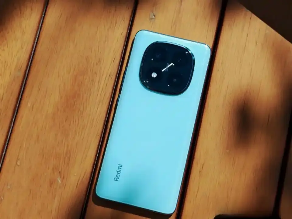 Rear view of the Redmi Note 15 Pro in a light blue finish, placed on a wooden surface