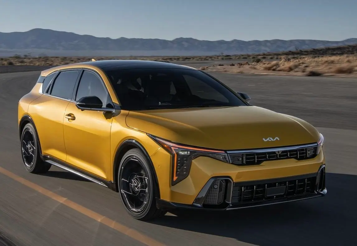 Yellow Kia K4 hatchback in motion on a road