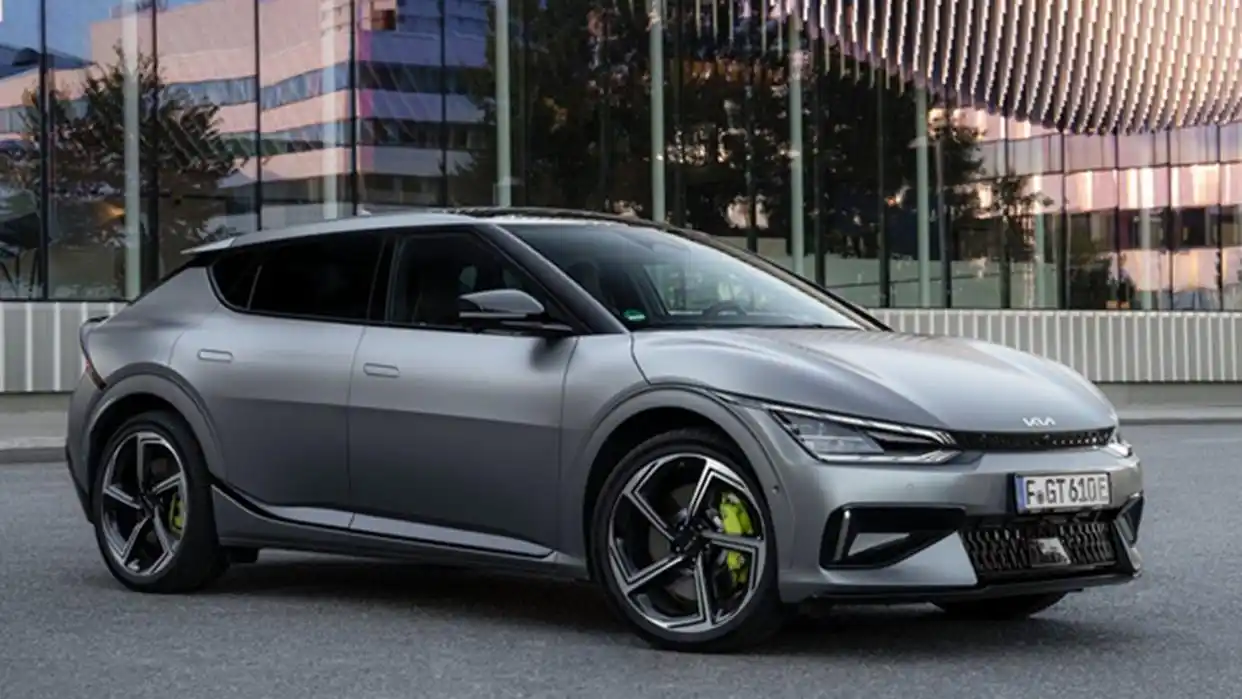 2025 Kia EV6 GT electric SUV front-side view parked outside a glass building