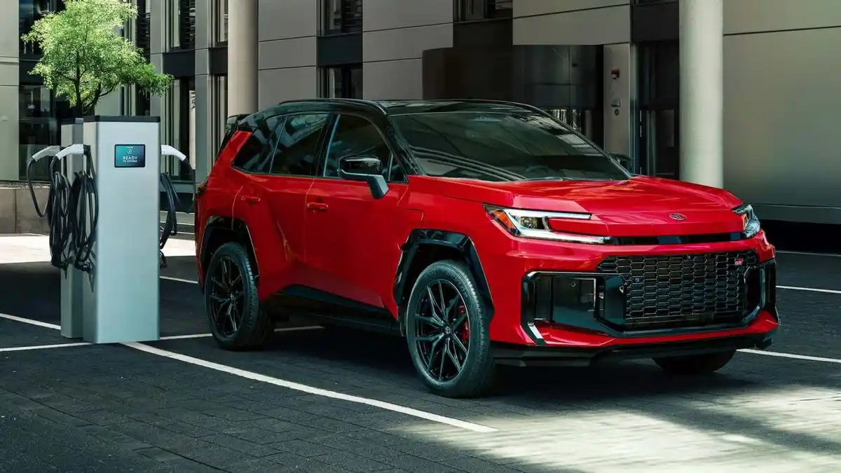 2025 Toyota RAV4 GR Sport electric SUV charging at an EV station, showcasing sporty red and black exterior