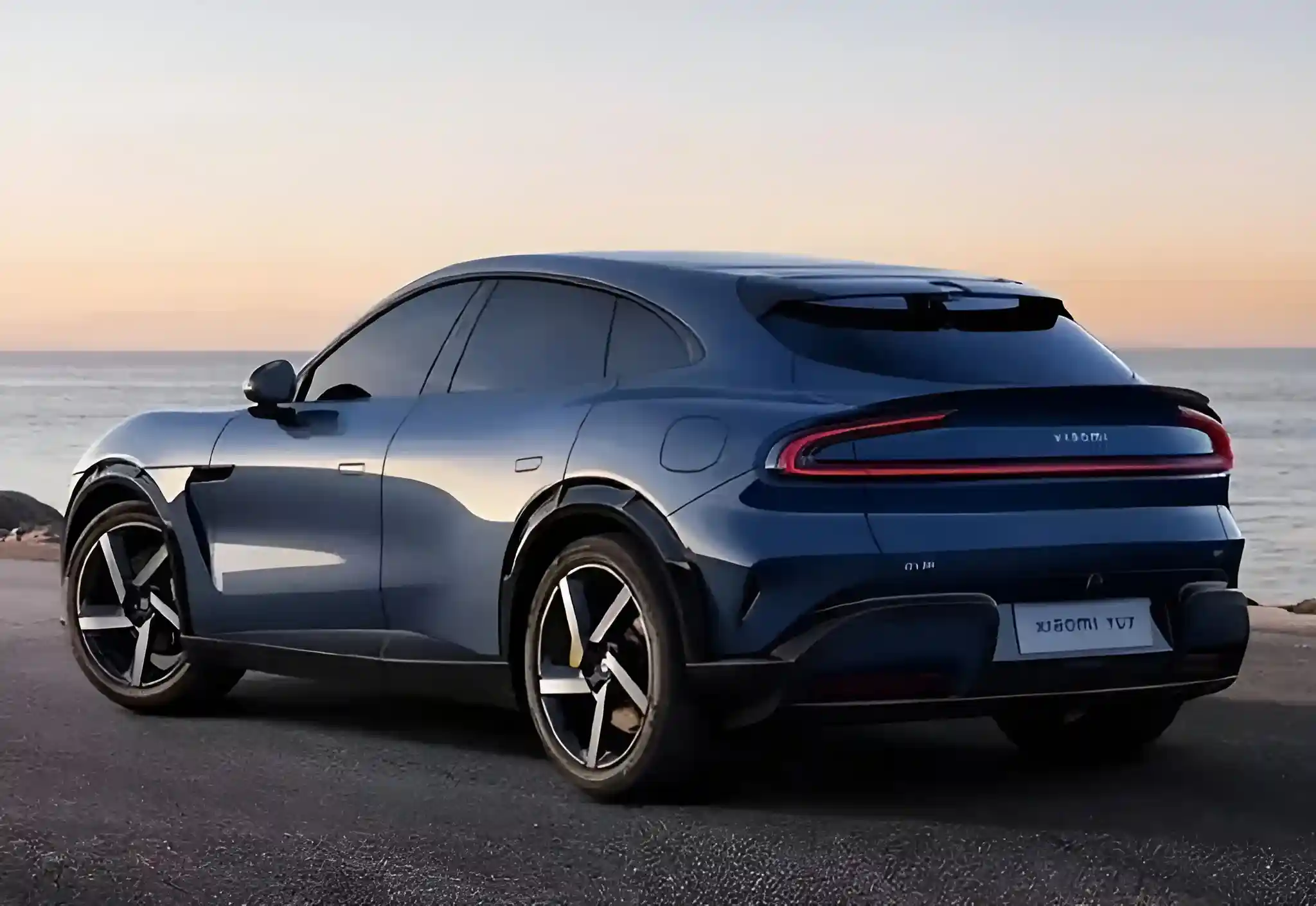 Rear view of the blue Xiaomi YU7 electric SUV by the sea