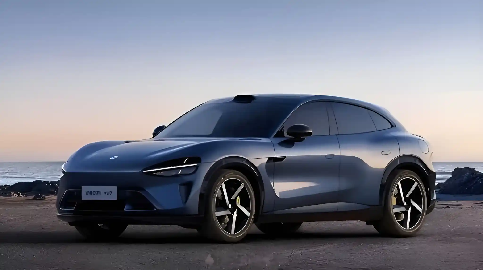 Xiaomi YU7 electric SUV on a beach at sunset.