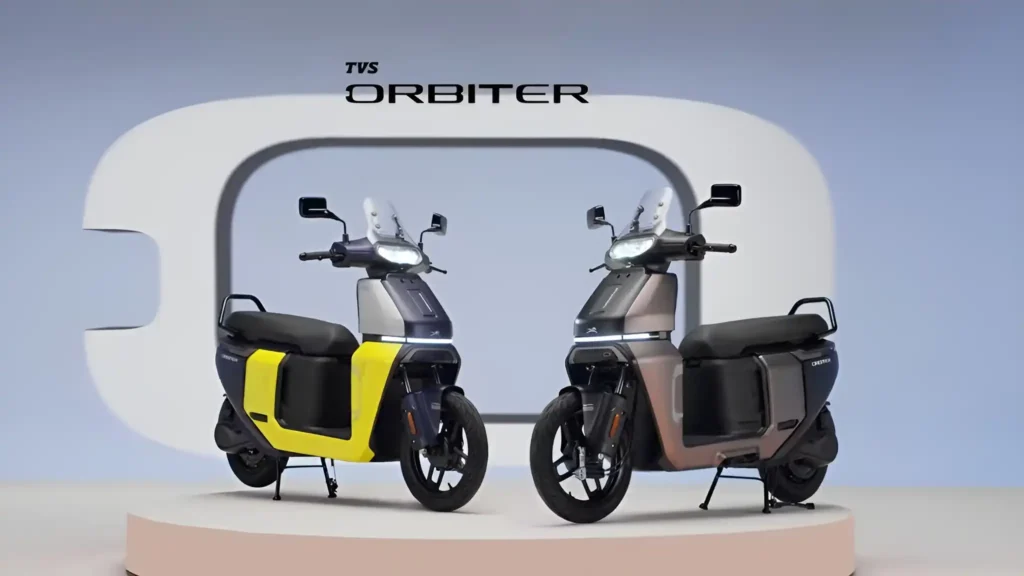 A yellow and a brown TVS Orbiter, a new two-tone electric scooter model, on a stage.