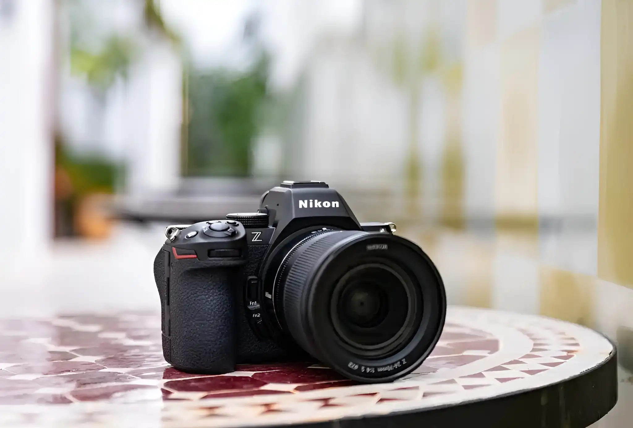 The Nikon Z5ii mirrorless camera sits on a decorative tiled table in a bright, outdoor setting.