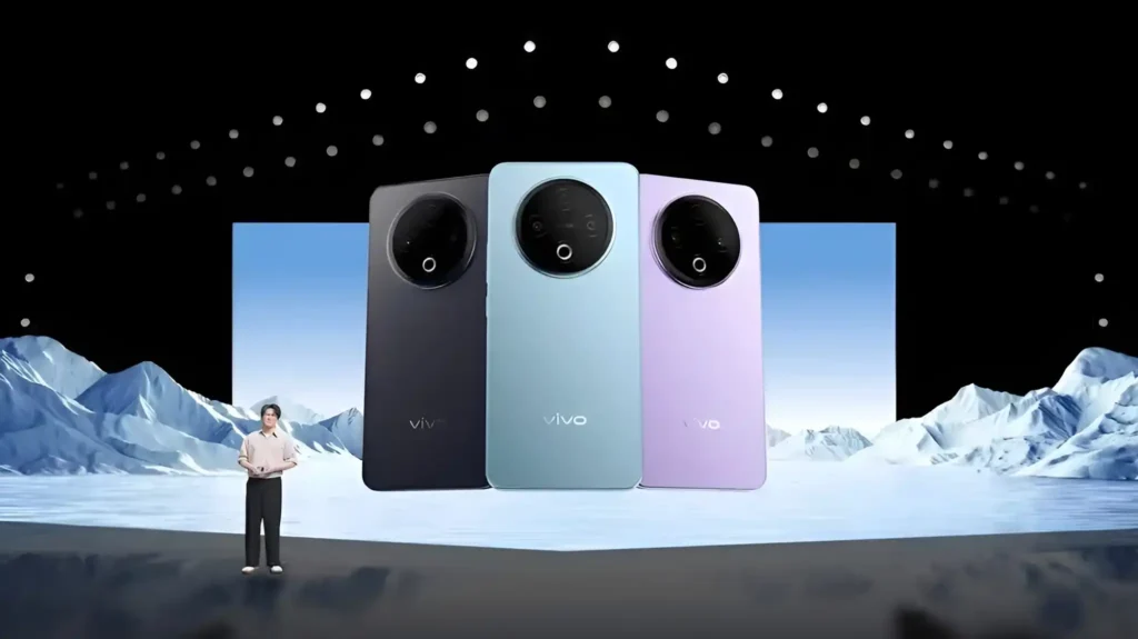 A man presents three new vivo y500 phones on a stage with a snowy backdrop. The phones are black, blue, and purple.