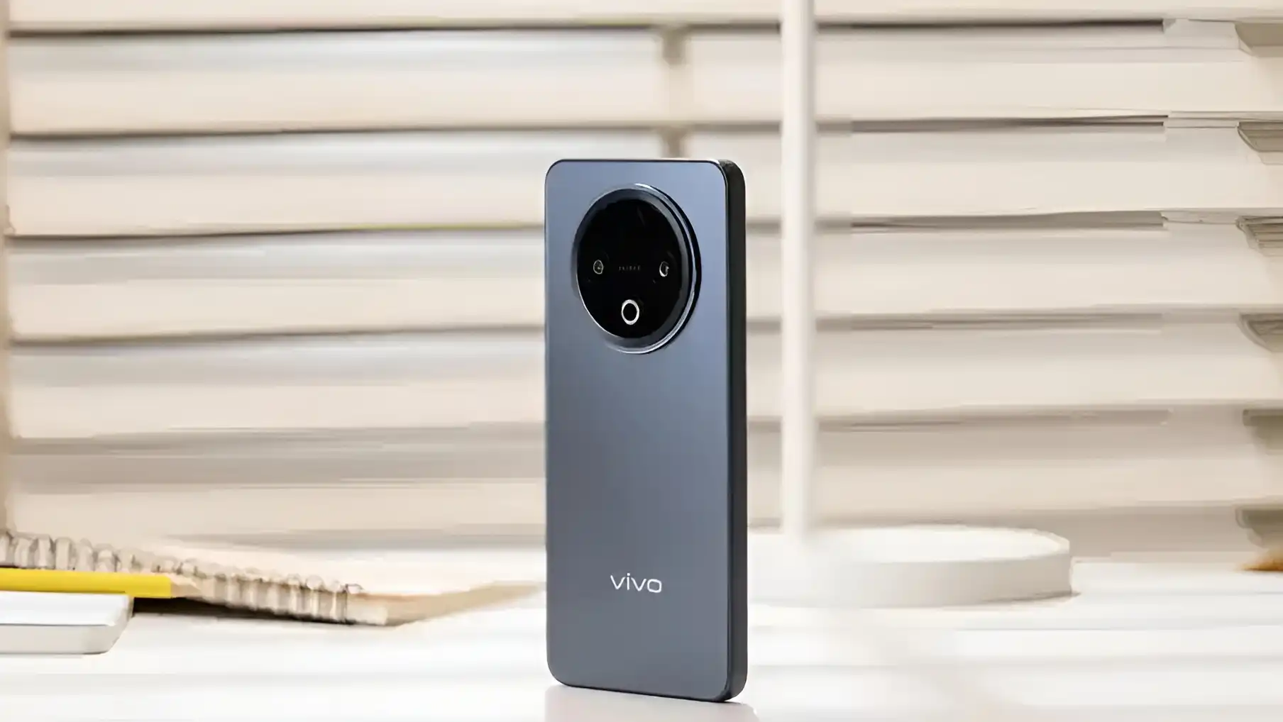 A vertical shot of the Vivo Y500 smartphone's back, highlighting its gray finish, circular camera module, and Vivo branding.