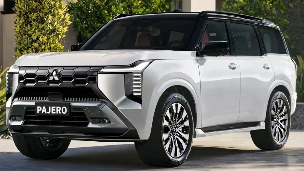 A modern white 2026 Mitsubishi Pajero 4x4 SUV with a black roof and rugged front grille is parked in a driveway.