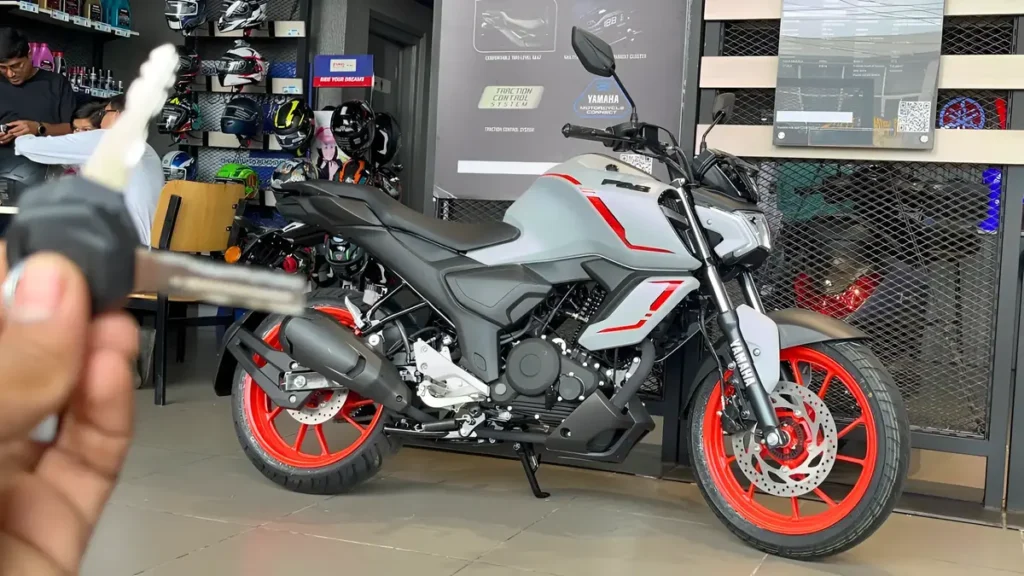 Yamaha FZS-FI Hybrid displayed at dealership with sporty grey body and red alloy wheels