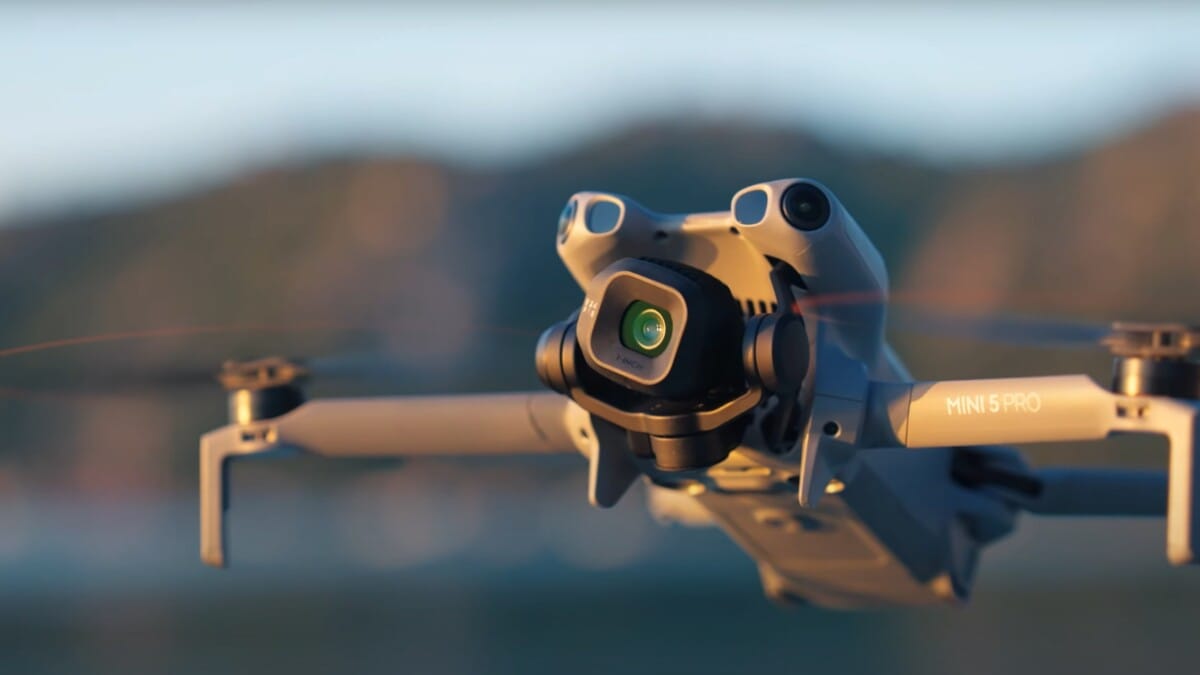 Close-up of DJI Mini 5 Pro drone camera with 50MP sensor capturing details during flight at sunset